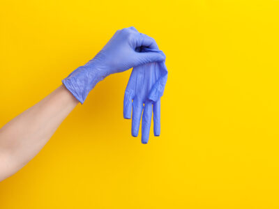 Step-by-step instructions on how to remove dirty gloves, doctor Step-by-step instructions on how to remove dirty gloves, doctor take off from hand nitrile syrgical medical purple glove on yellow background, horizontal, copy space, place for text